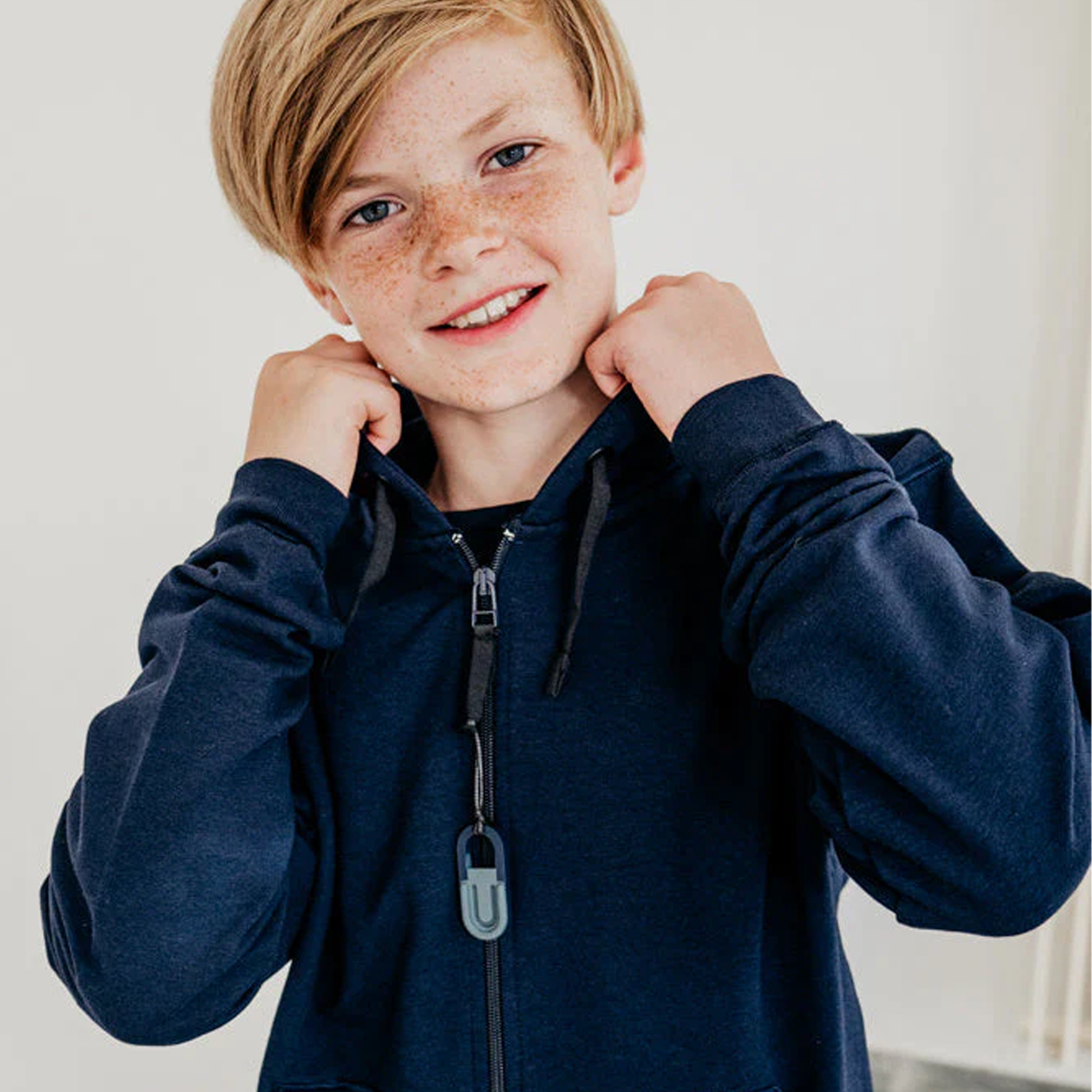 Kind mit Anhänger an der Jacke