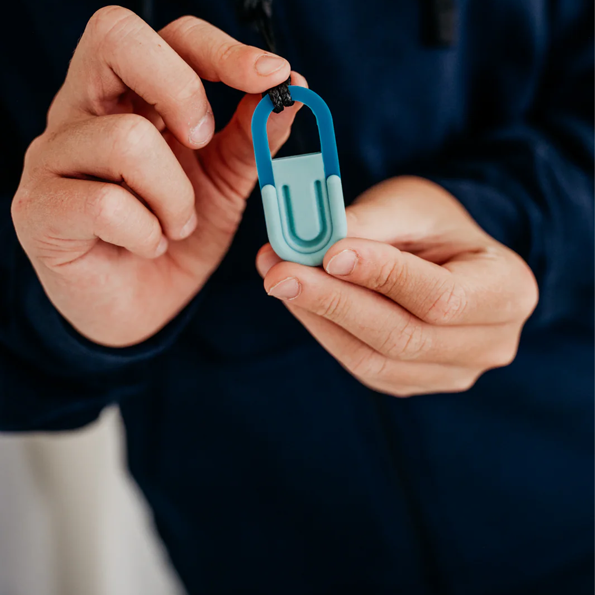 Kind hält zwischen beiden Händen einen Anhänger