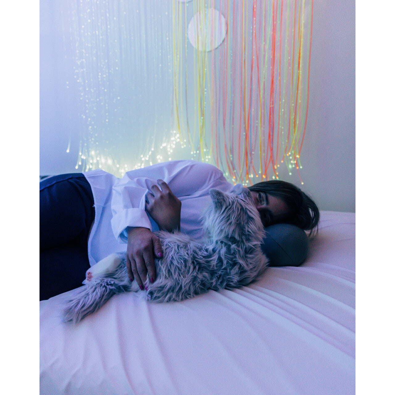 Frau vor Lichtervorhang mit Katze