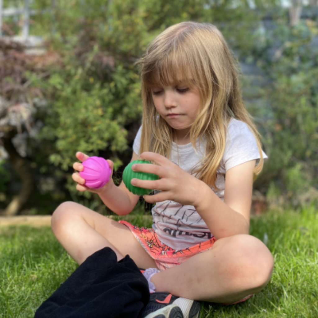 Kind hält zwei Bälle in der Hand