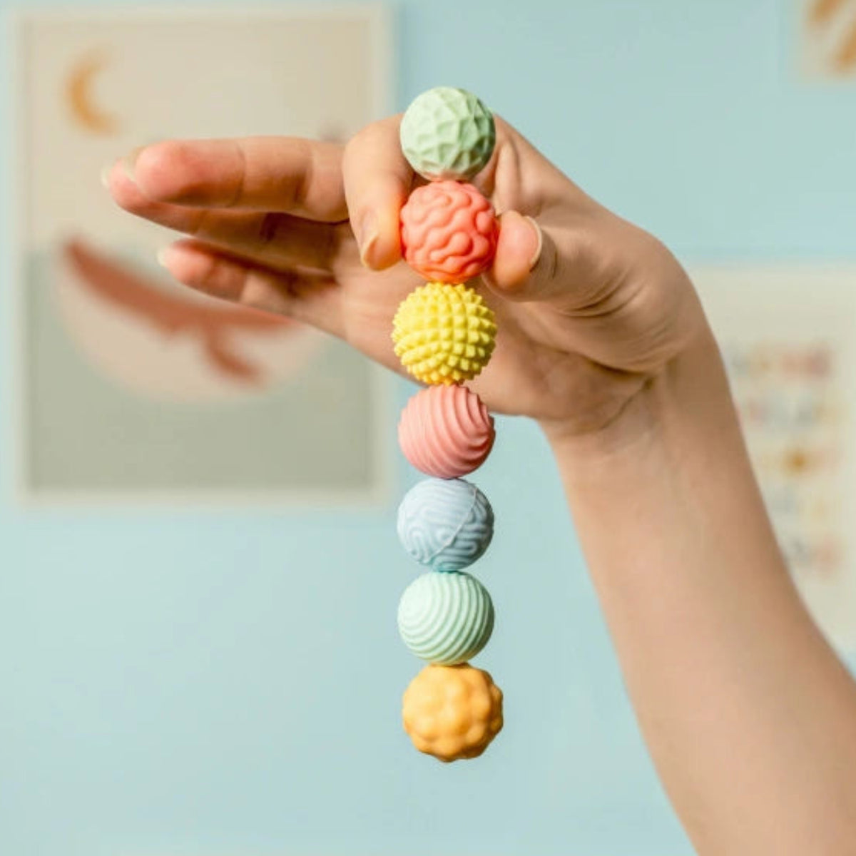 Hand hält bunte magnetische Kugeln fest