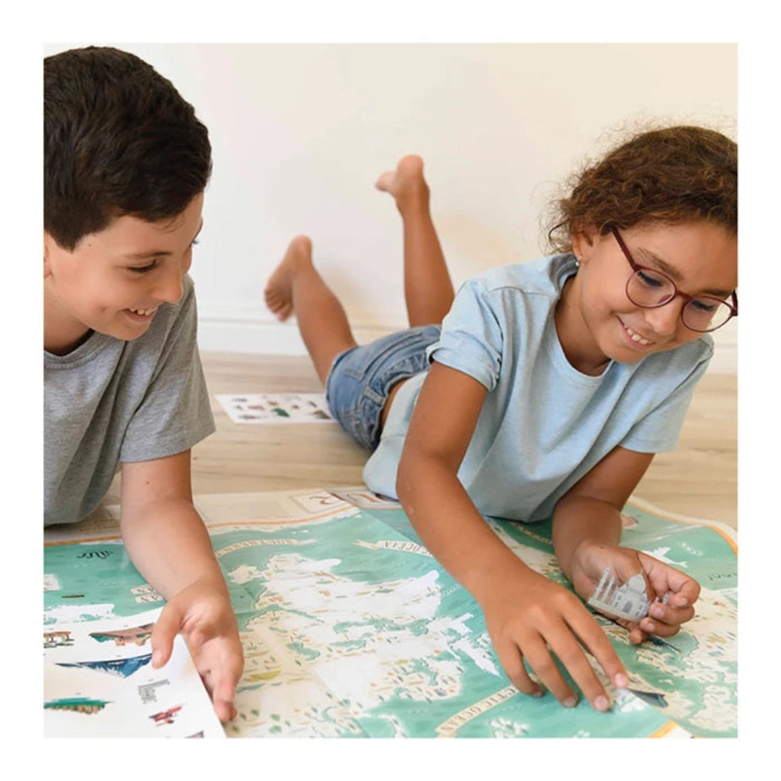 Kinder kleben Bilder auf Lernposter