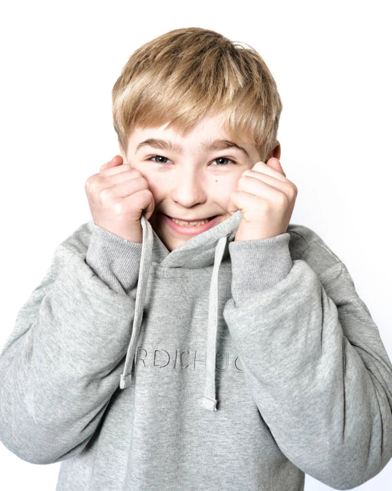 Kind zieht sich Pullover ans Gesicht