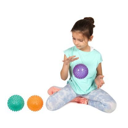 Kind spielt mit lila Ball