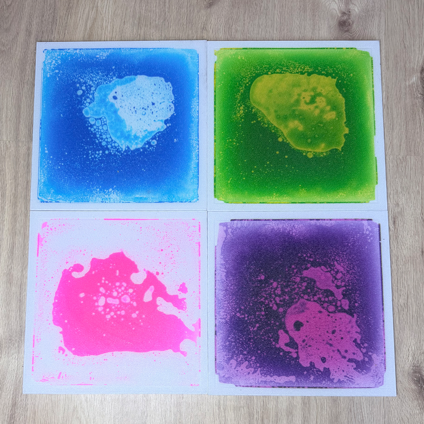 vier verschiedene Bodenfliesen mit Flüssigkeit