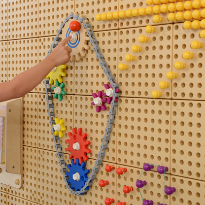 Kind spielt an Wand Zahnräder