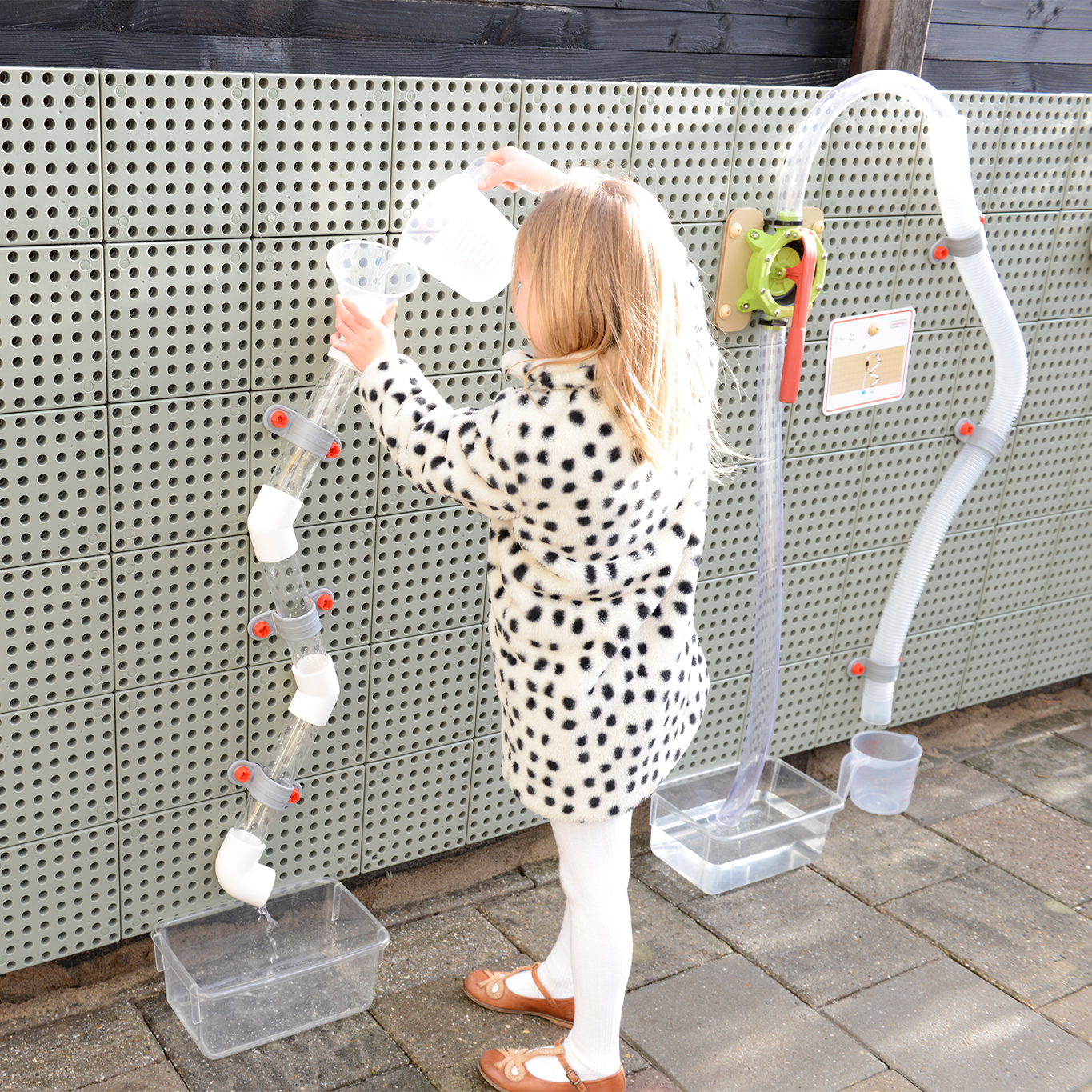 Kind spielt an Wasserrohre