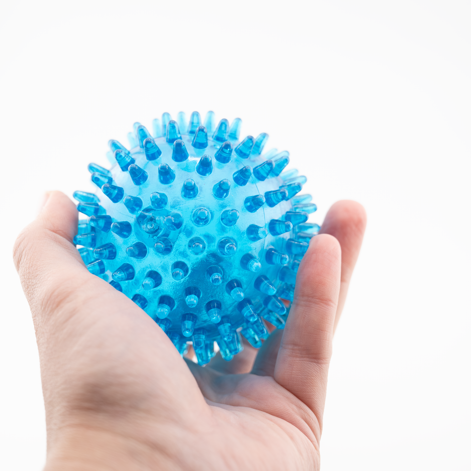 Hand hält blauen Noppenball