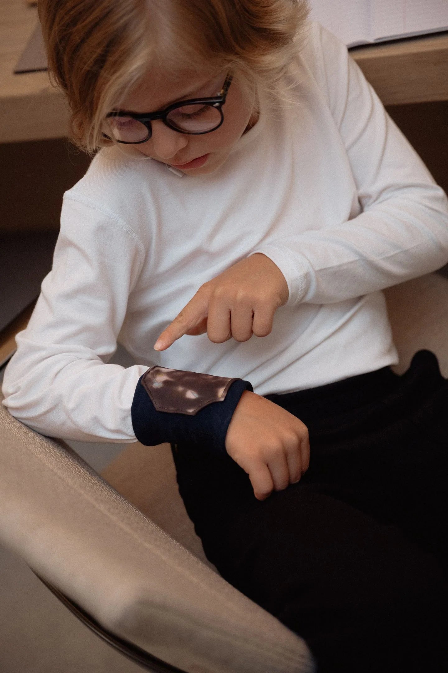 Kind zeigt mit Finger auf Armband