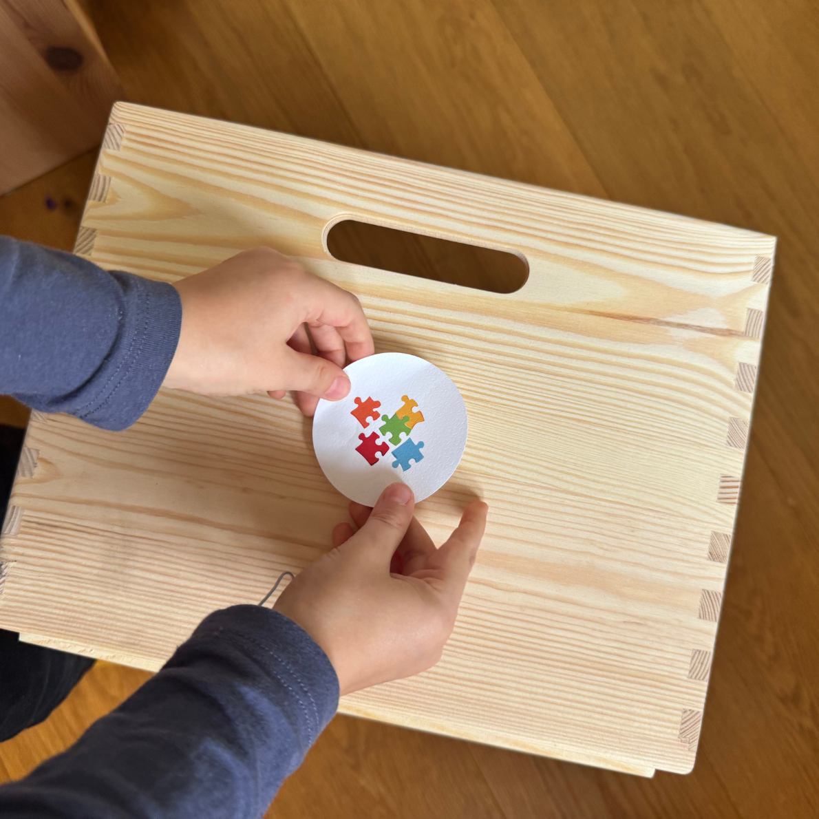 Aufkleber wird aufgebracht auf Spielkiste