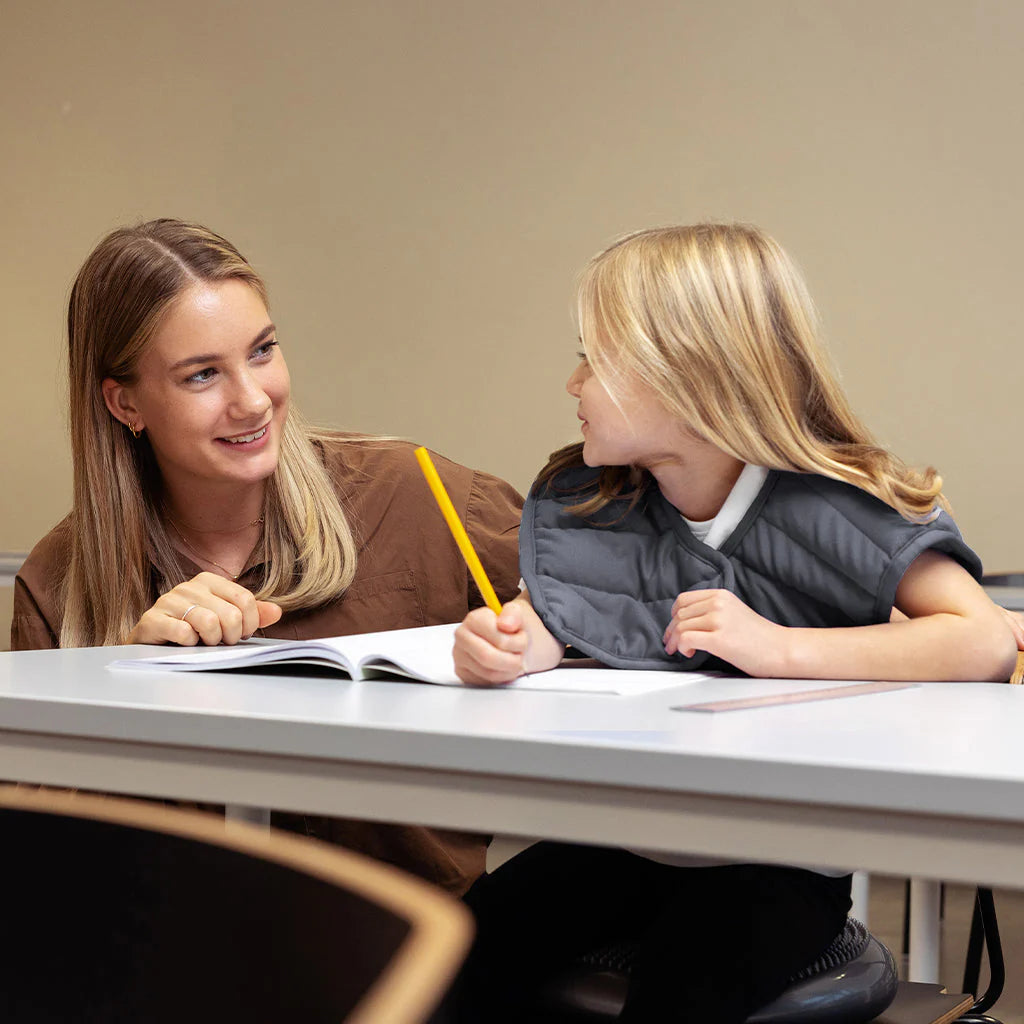 Kind mit Schulterdecke und Lehrerin
