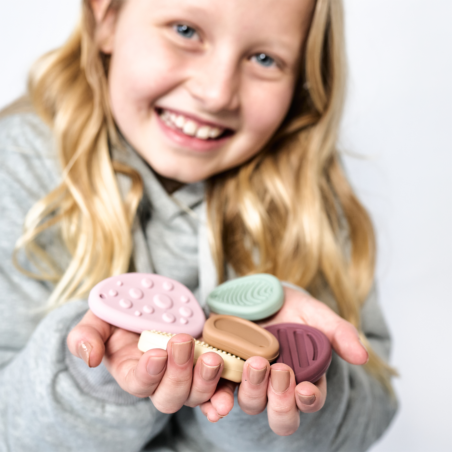 Kind hält Steine in die Kamera