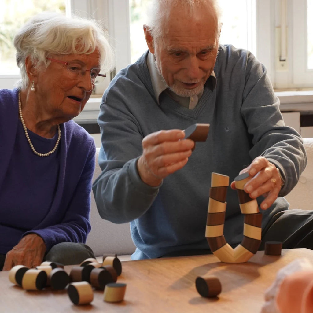 Zwei Erwachsene bauen mit Steinen