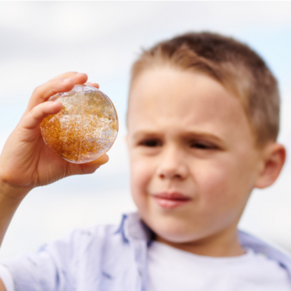 Junge hält orangenen Ball in der Hand