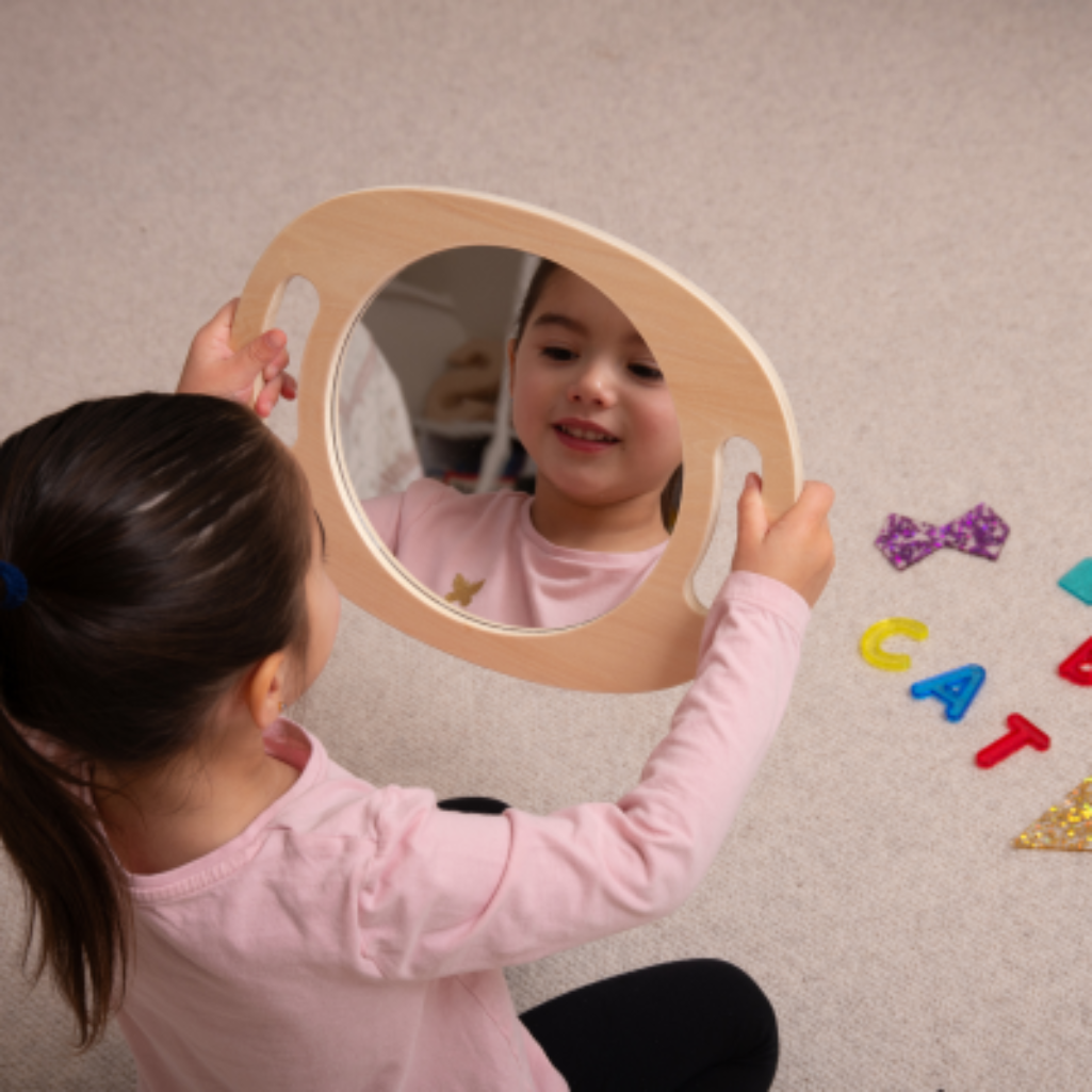 Kind lacht in Spiegel