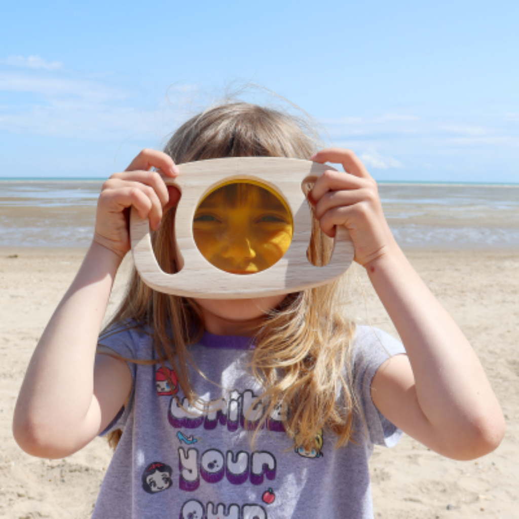 Kind schaut durch gelbe Scheibe