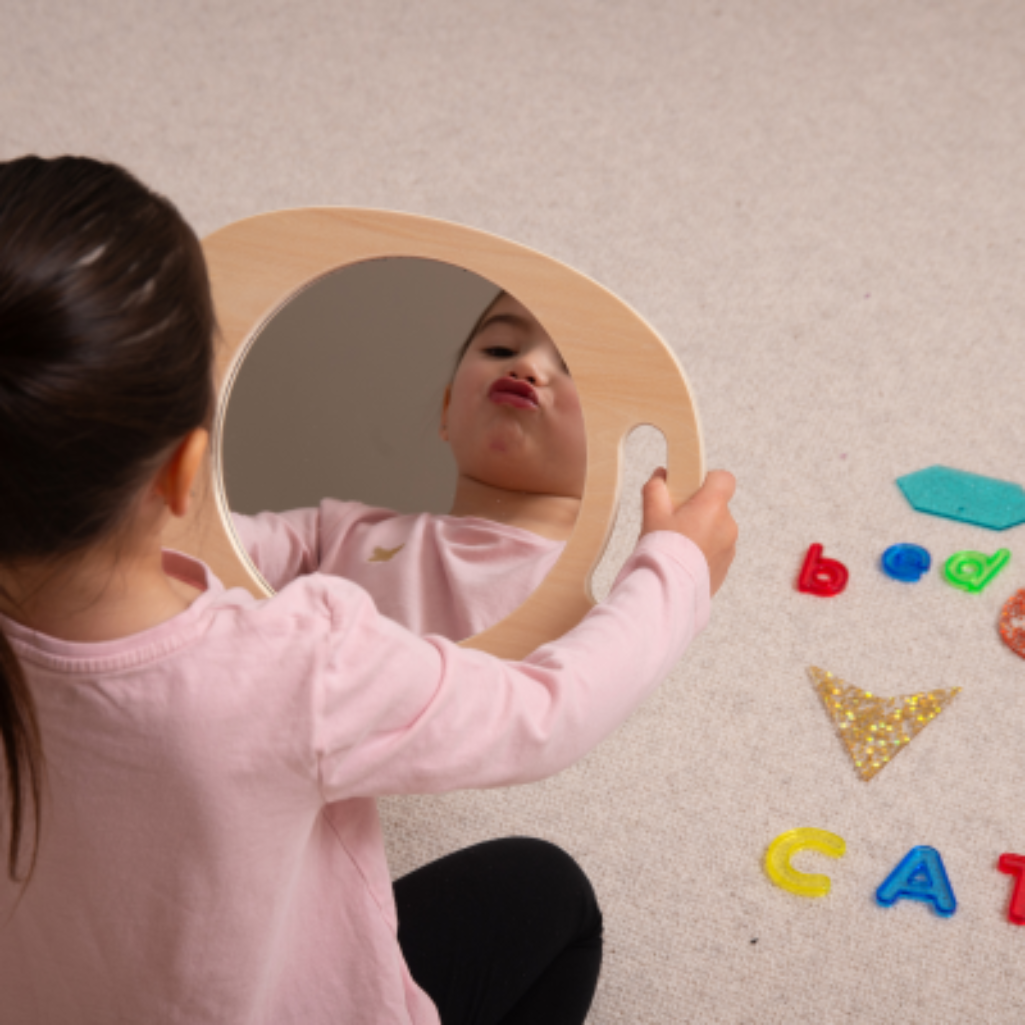 Kind macht Grimasse zum Spiegel