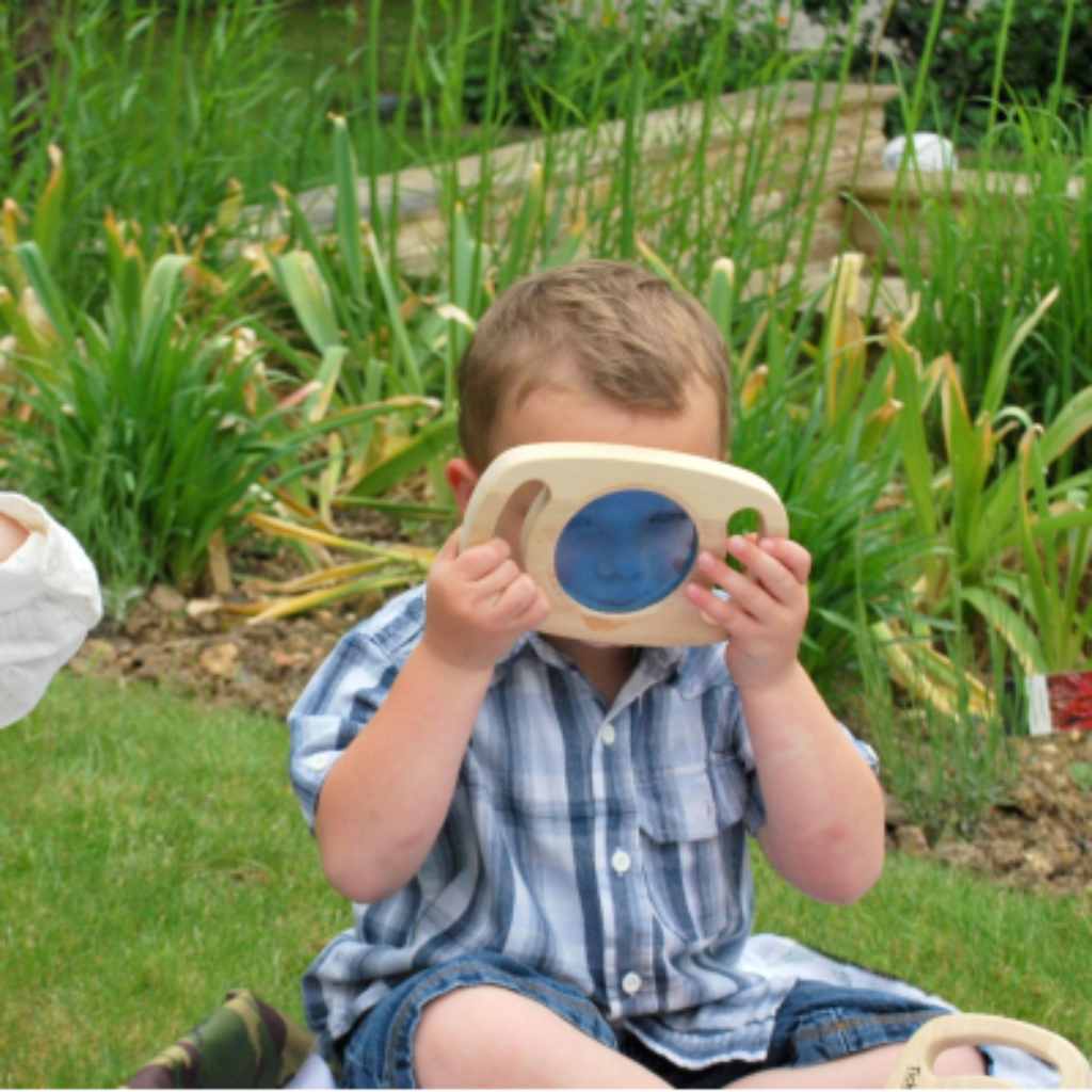 Kind schaut durch blaue Scheibe