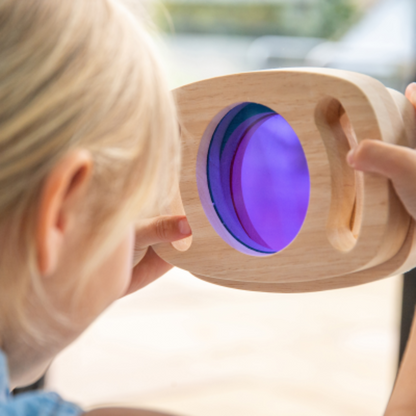 Kind schaut durch Lila Scheibe