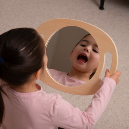 Kind schaut in den Mund am Spiegel