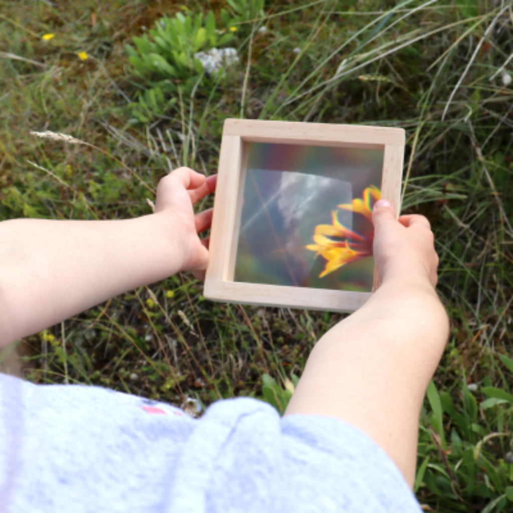 Kind hält Blume unter Rahmen